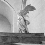 Monochrome image of Winged Victory of Samothrace statue in Paris's Louvre Museum.